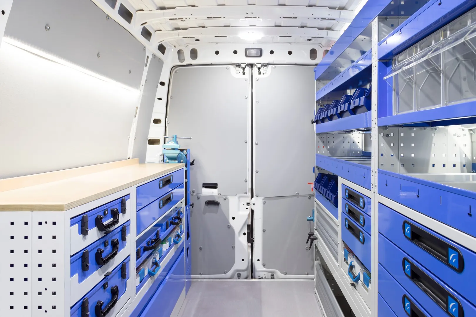 Interno di furgone allestito Tecnolam con banco da lavoro e cassettiere su entrambi i lati